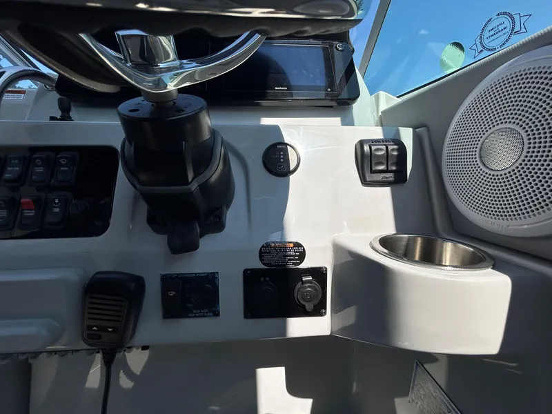 Slide: The Image of Control panel of 2025 Regal 26 XO boat with steering wheel and speaker. - 14