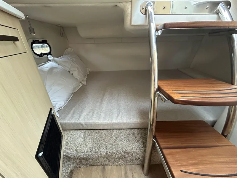 Slide: The Image of Cozy cabin interior of 2025 Regal 26 XO boat with wooden steps and bedding. - 21