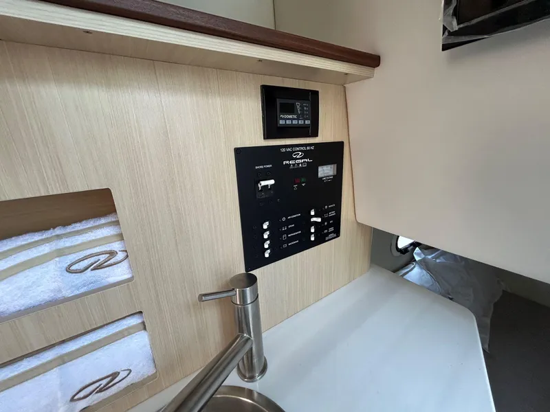 Slide: The Image of Control panel and sink area inside 2025 Regal 26 XO boat cabin. - 22