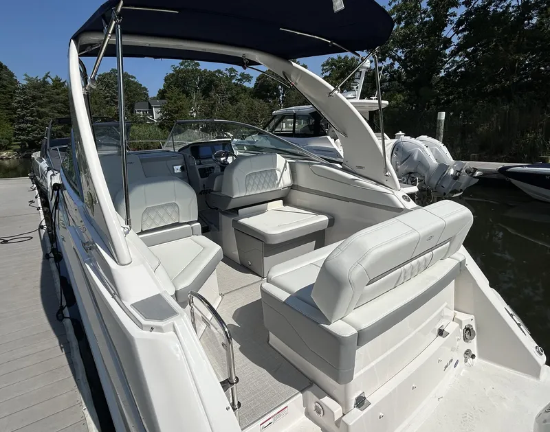 Slide: The Image of 2025 Regal 26 XO boat interior with white seating, docked in a marina. - 4