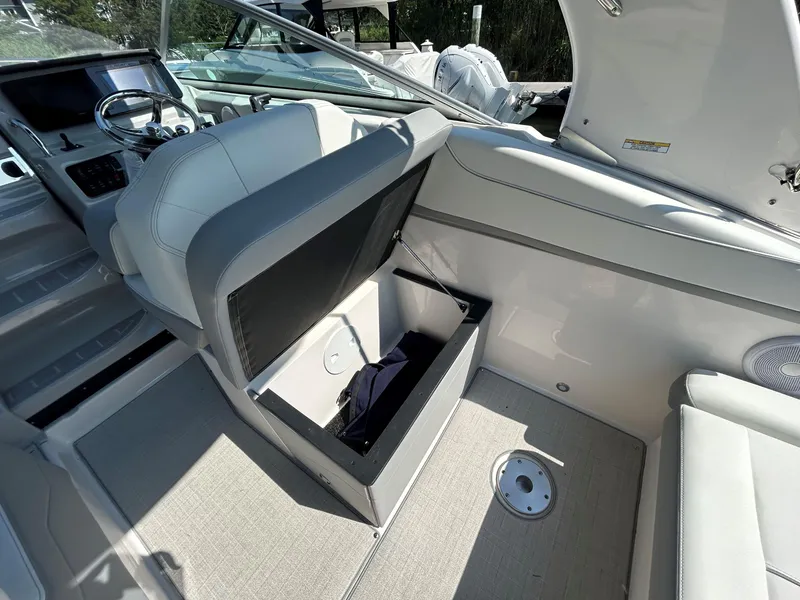 Slide: The Image of 2025 Regal 26 XO boat interior with open storage compartment and steering wheel. - 6