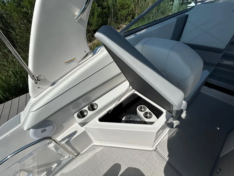 Slide: The Image of 2025 Regal 26 XO boat interior with open storage compartment and cup holders. - 8