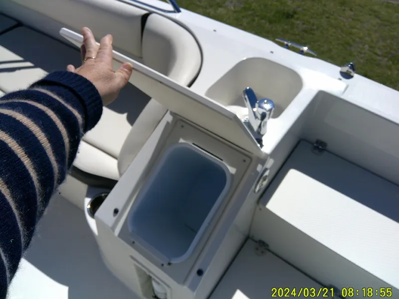 Slide: The Image of 2022 Stingray 212SC boat interior with open storage compartment and seating area. - 21