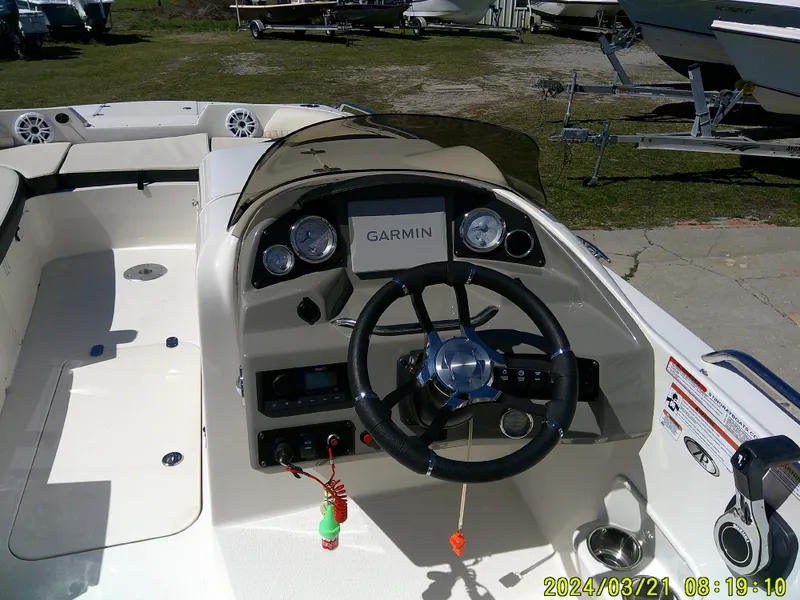 Slide: The Image of 2022 Stingray 212SC boat dashboard with Garmin navigation system and steering wheel. - 23