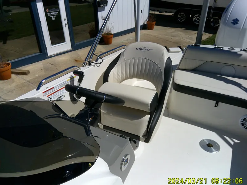 Slide: The Image of 2022 Stingray 212SC boat interior with steering wheel and seating area. - 29