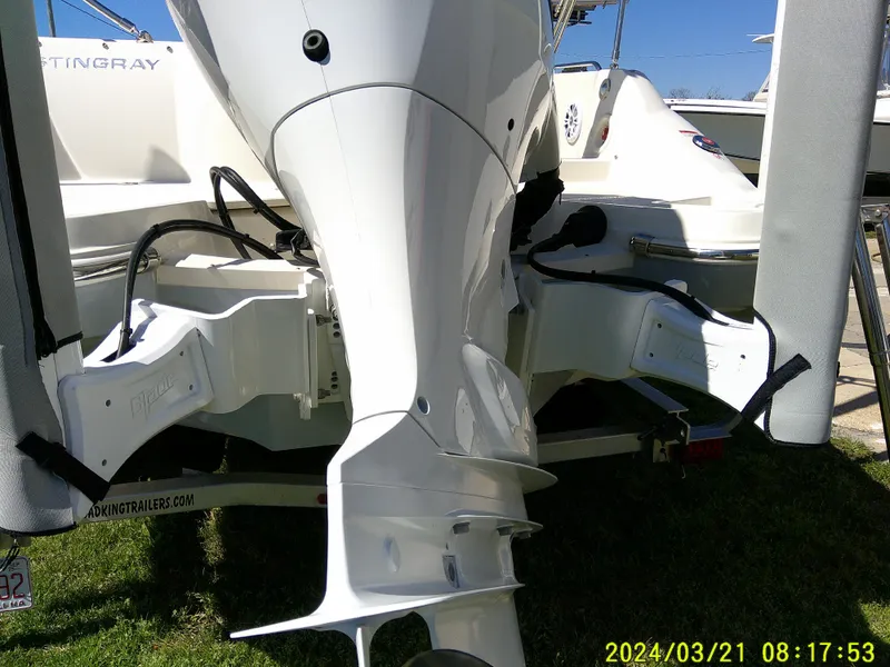 Slide: The Image of 2022 Stingray 212SC boat engine and stern view, parked on a trailer. - 6