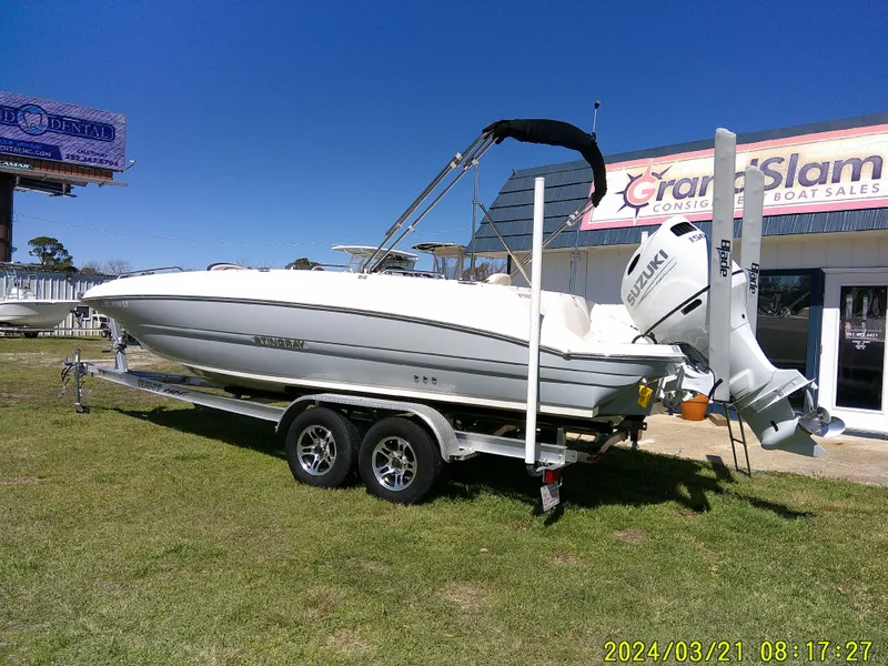 Slide: The Image of 2022 Stingray 212SC boat on trailer, parked outside a boat sales shop. - 8