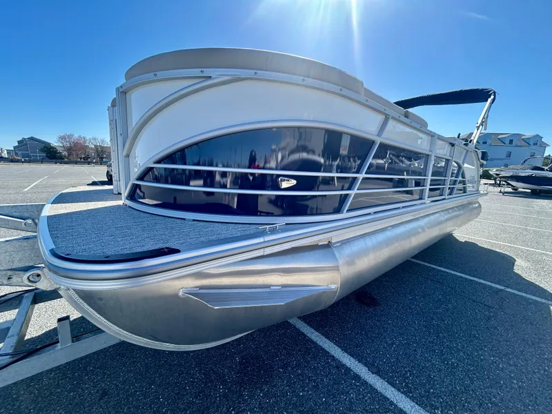 Slide: The Image of 2025 Berkshire 23CL STS 3.0 pontoon boat in a parking lot under clear blue sky. - 3