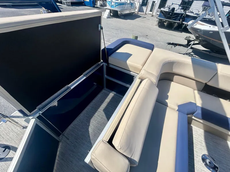 Slide: The Image of 2025 Berkshire 23CL STS 3.0 pontoon boat interior with beige seating and storage compartment. - 6