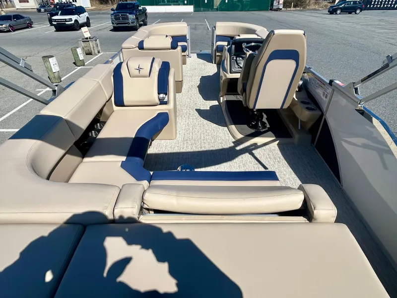 Slide: The Image of 2025 Berkshire 23CL STS 3.0 pontoon boat with beige and blue seating, parked outdoors. - 8