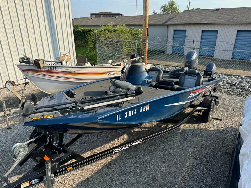 Slide: The Image of 2014 Polar Kraft Bass TX 175 Pro boat on trailer, parked outdoors. - 2