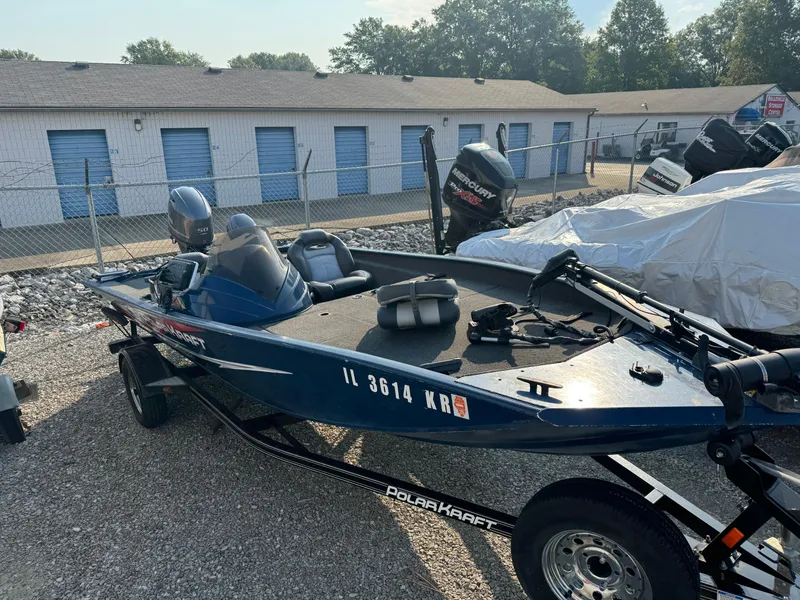 Slide: The Image of 2014 Polar Kraft Bass TX 175 Pro boat parked outdoors near storage units. - 3