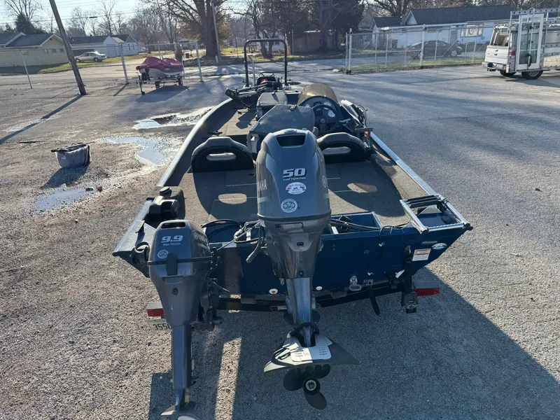 Slide: The Image of 2014 Polar Kraft Bass TX 175 Pro boat with dual outboard motors in a parking lot. - 8