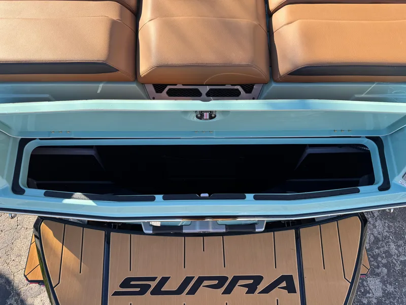 Slide: The Image of 2025 Supra SL 450 boat interior with open storage compartment and tan seating. - 15