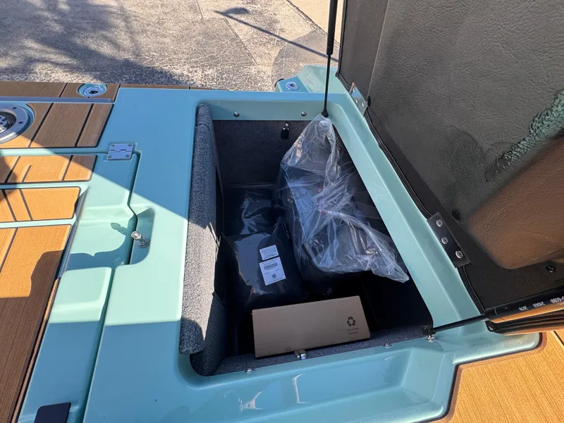 Slide: The Image of Open storage compartment in 2025 Supra SL 450 boat, showing packaged items inside. - 22