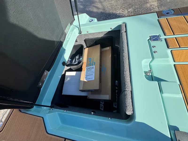 Slide: The Image of Open storage compartment in 2025 Supra SL 450 boat, containing various items. - 23