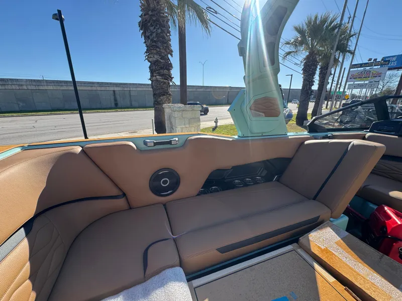 Slide: The Image of 2025 Supra SL 450 interior with tan leather seats and speaker, under clear blue sky. - 25