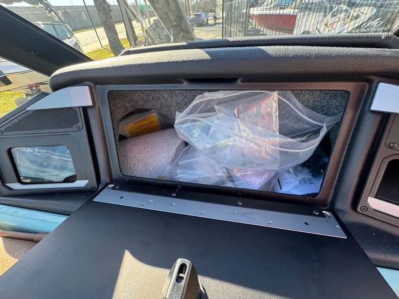 Slide: The Image of 2025 Supra SL 450 dashboard storage compartment with various items inside. - 46