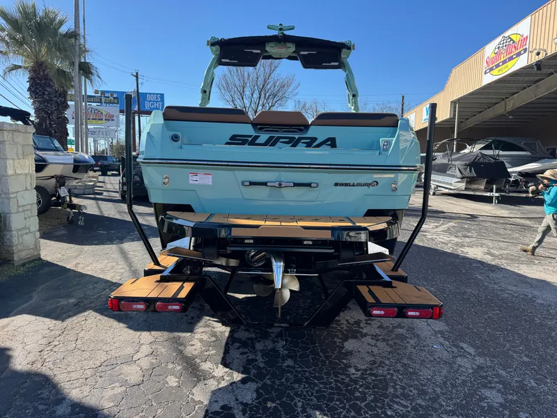 Slide: The Image of 2025 Supra SL 450 boat, rear view, parked outdoors on a sunny day. - 8