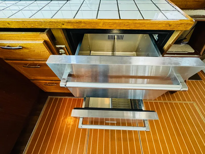 Slide: The Image of Kitchen area of 1965 Chris-Craft 38 Constellation with open stainless steel drawers. - 15