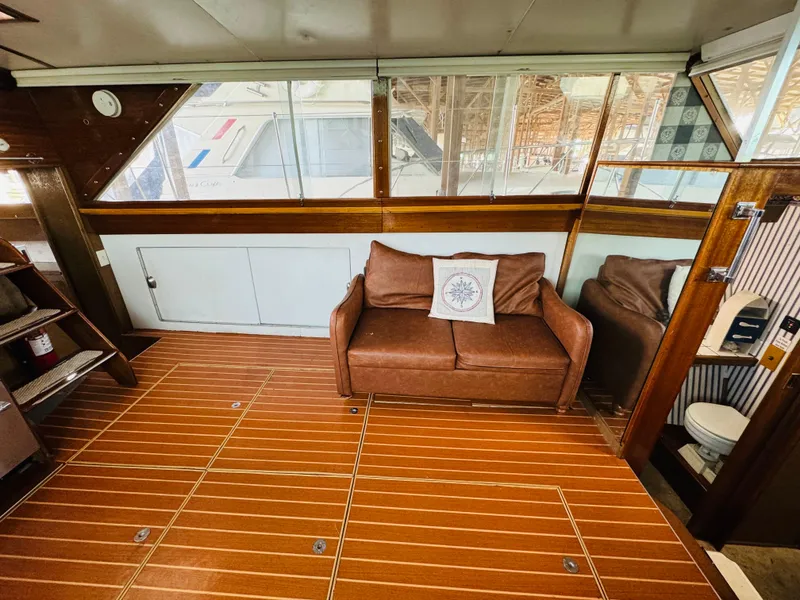Slide: The Image of Interior of 1965 Chris-Craft 38 Constellation with wooden flooring and brown leather sofa. - 16