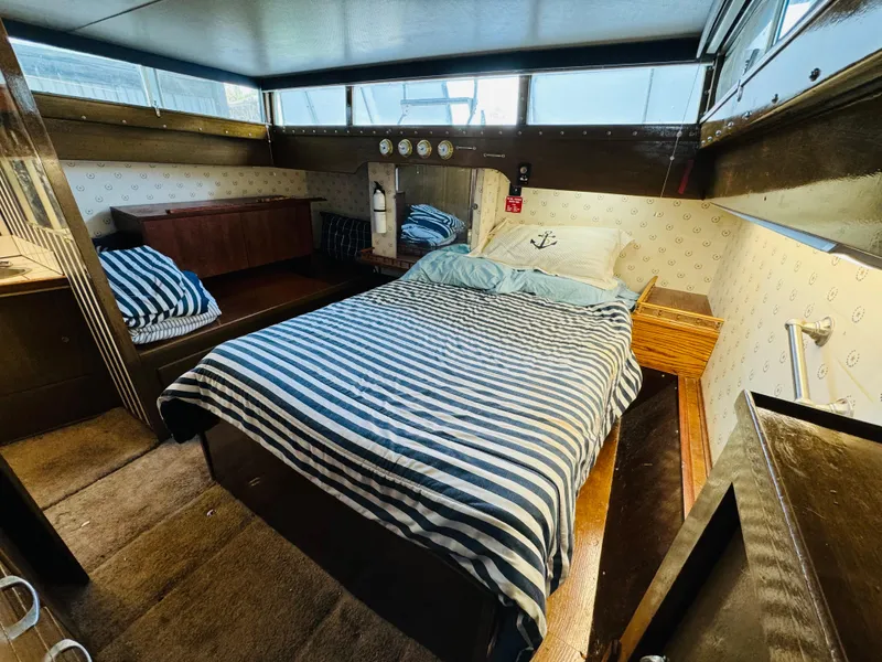 Slide: The Image of 1965 Chris-Craft 38 Constellation cabin with striped bedding and nautical decor. - 17