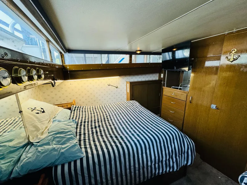 Slide: The Image of 1965 Chris-Craft 38 Constellation cabin with striped bedding and wooden interior. - 19