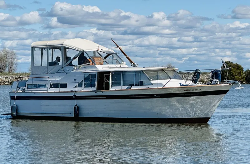 Slide: The Image of 1965 Chris-Craft 38 Constellation yacht cruising on a calm lake under a cloudy sky. - 2