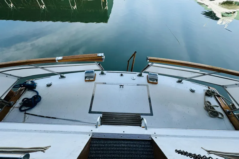 Slide: The Image of 1965 Chris-Craft 38 Constellation boat deck with wooden railings and calm water reflection. - 31
