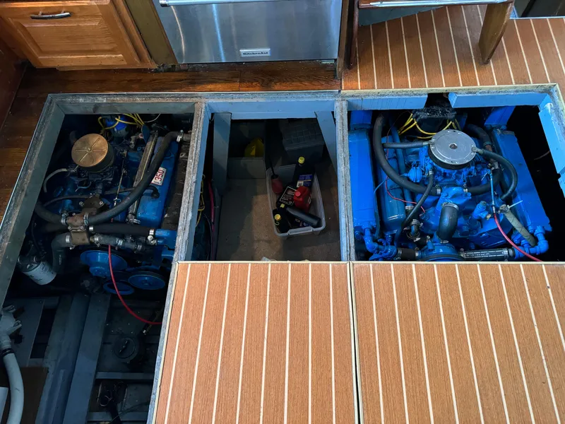 Slide: The Image of 1965 Chris-Craft 38 Constellation engine compartment with twin blue engines and wooden flooring. - 32