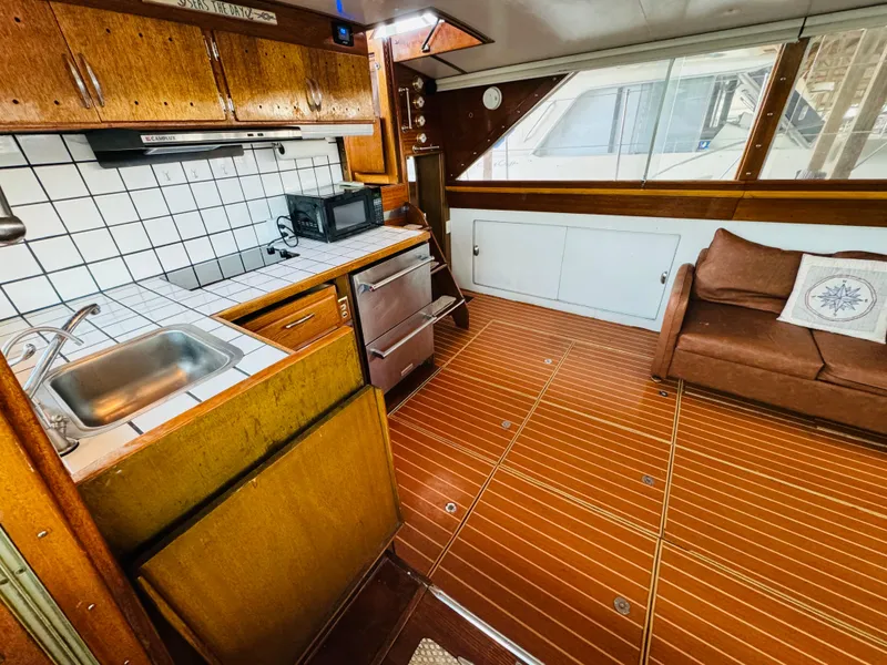 Slide: The Image of 1965 Chris-Craft 38 Constellation interior with kitchen, sofa, and wood flooring. - 8