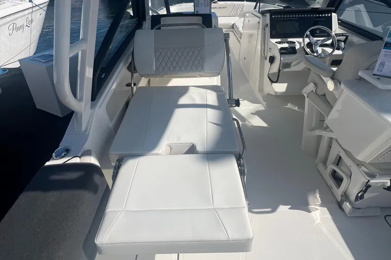 Slide: The Image of 2024 World Cat 260 DC-X boat interior with white seating and modern dashboard. - 13