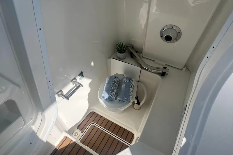 Slide: The Image of 2024 World Cat 260 DC-X boat bathroom with wooden flooring and compact design. - 14