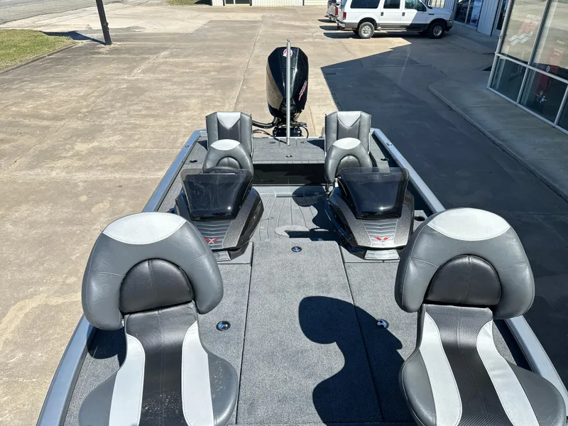 Slide: The Image of 2025 Vexus AVX 1895S boat interior with seating and motor, parked outdoors. - 8