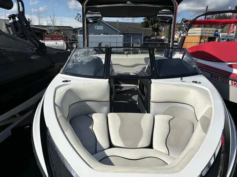 Slide: The Image of 2013 Malibu Wakesetter 20 VTX boat with white and gray interior, docked outdoors. - 2