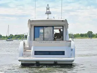 Slide: The Image of 2019 Prestige 460S yacht cruising on a calm river with scenic background. - 10