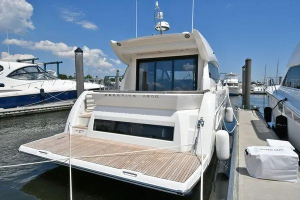 Slide: The Image of 2019 Prestige 460S yacht docked at marina, showcasing sleek design and spacious deck. - 12