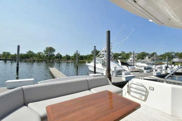 Slide: The Image of 2019 Prestige 460S yacht docked at marina with seating area and table. - 17
