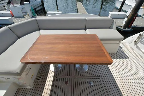 Slide: The Image of 2019 Prestige 460S yacht with elegant wooden table and cushioned seating on deck. - 18