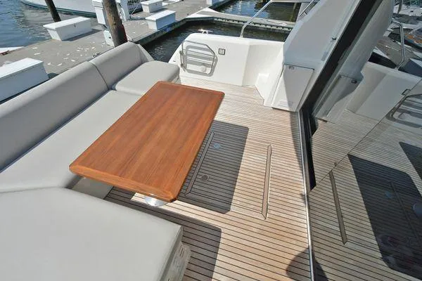 Slide: The Image of 2019 Prestige 460S yacht deck with wooden table and cushioned seating. - 19