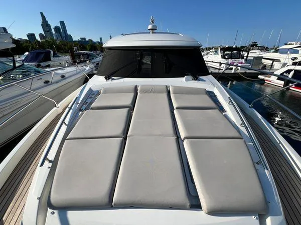 Slide: The Image of 2019 Prestige 460S yacht with sunbathing deck, docked in a marina, city skyline in background. - 22
