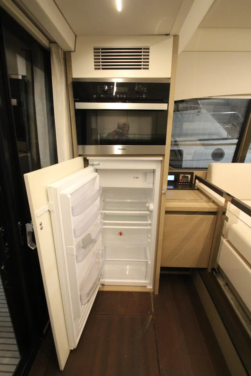 Slide: The Image of Modern kitchen area in a 2019 Prestige 460S yacht with open fridge and microwave. - 29