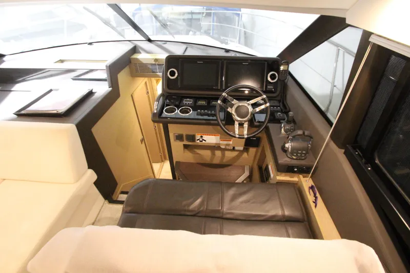 Slide: The Image of 2019 Prestige 460S yacht helm with modern controls and leather seating. - 35