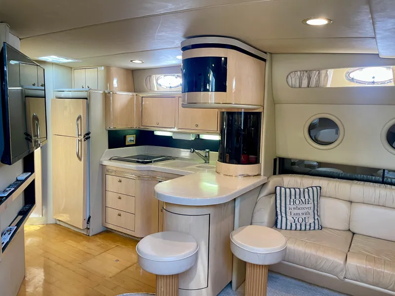 Slide: The Image of Luxurious interior of a 1999 Sea Ray 500 Sundancer yacht with modern kitchen and seating area. - 14