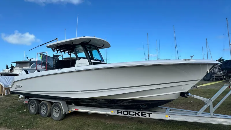 Slide: The Image of 2022 Boston Whaler 330 Outrage boat on a trailer, clear sky background. - 19