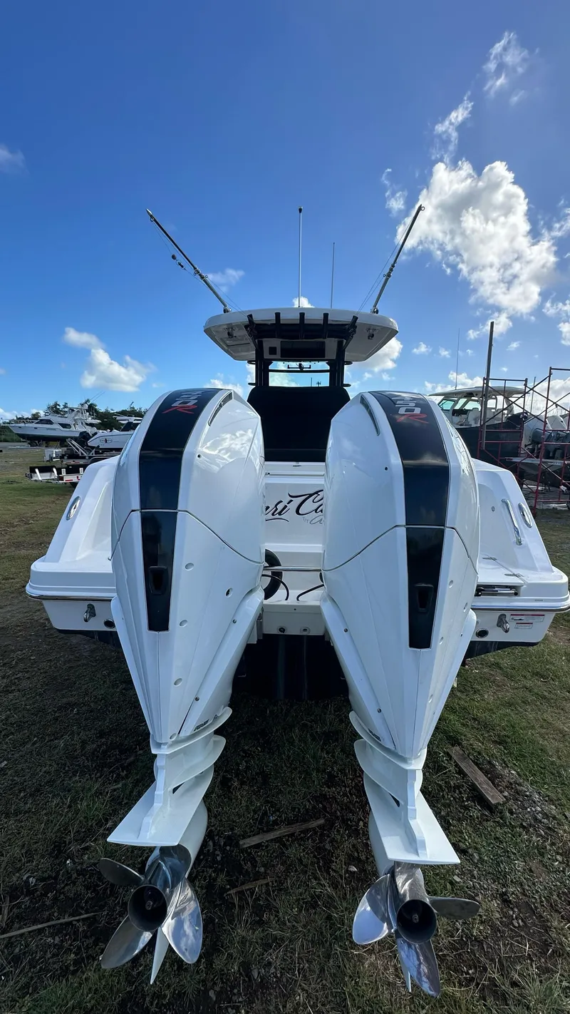 Slide: The Image of 2022 Boston Whaler 330 Outrage boat with dual outboard engines, viewed from the rear. - 21