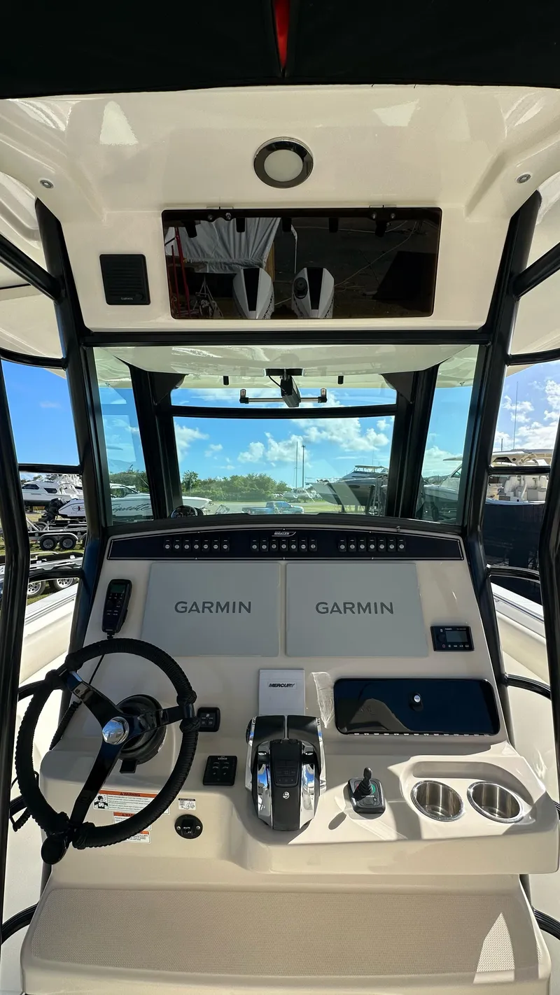 Slide: The Image of 2022 Boston Whaler 330 Outrage helm with Garmin navigation system and steering wheel. - 22