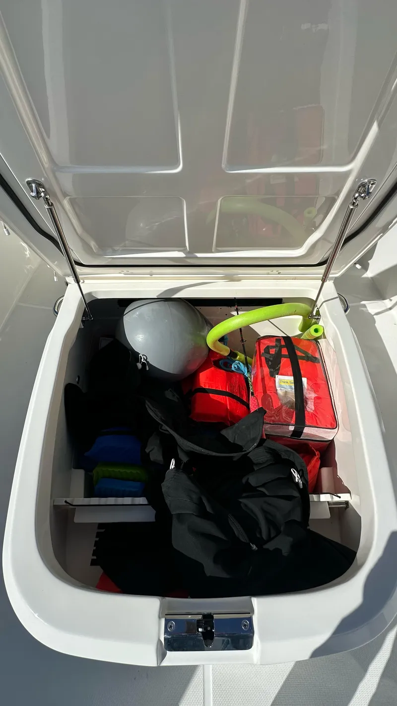 Slide: The Image of Storage compartment on a 2022 Boston Whaler 330 Outrage, filled with boating gear. - 6