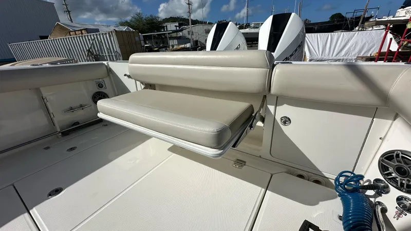 Slide: The Image of 2022 Boston Whaler 330 Outrage boat interior with foldable seating and twin engines. - 7