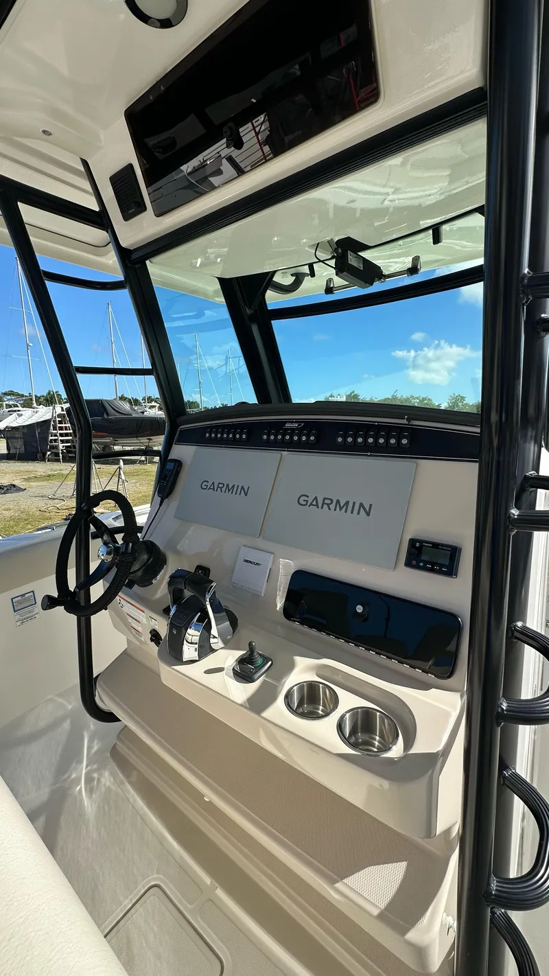Slide: The Image of 2022 Boston Whaler 330 Outrage helm with Garmin navigation systems and steering wheel. - 8